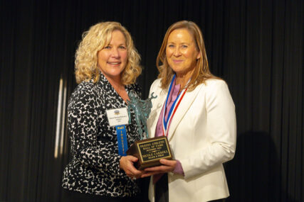 Nicole Carroll-Lewis receiving her hall of fame plaque from Gena