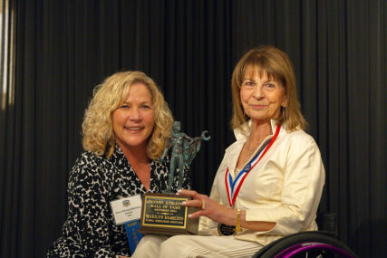 Marilyn Hamilton receiving her award plaque from Gena Behrens