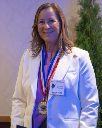 Nicole Carroll-Lewis posing with her inductee medal
