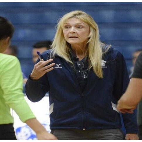 Coaching Vicki Samarin in discussion with her volleyball players during a match