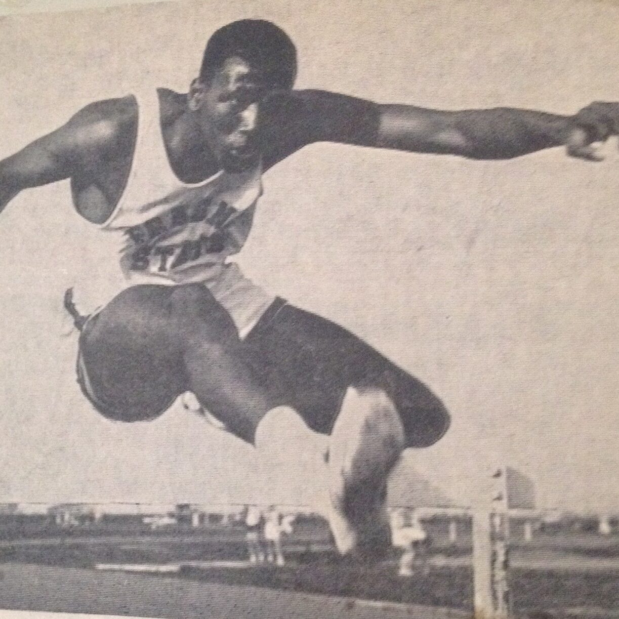Sid Nikolas long jumping over a hurdle in Track and Field